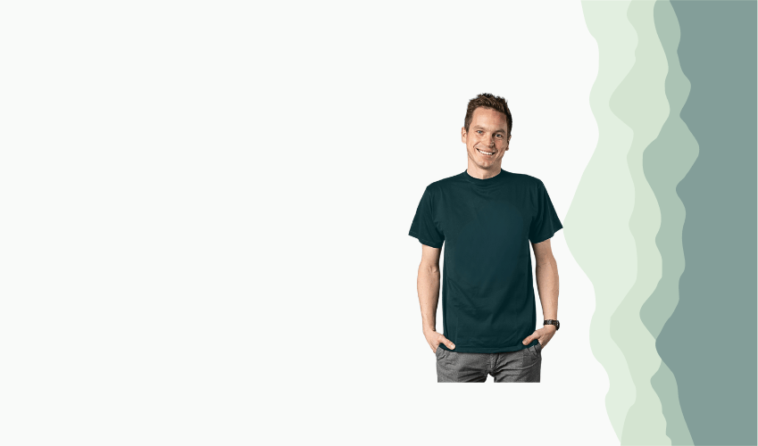 Ein freundlich lächelnder, weißer Mann mit braunen Haaren und dunkelgrünem T-Shirt